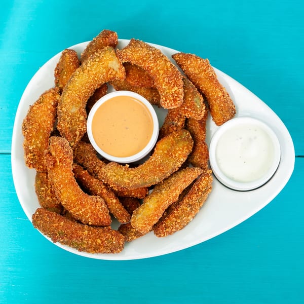 JoVi's Tacos' fried avocado fries with two dipping sauces on a white plate.