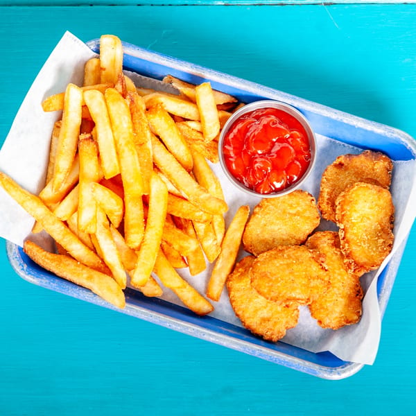 A blue tray with golden french fries, chicken nuggets, and a side of ketchup.